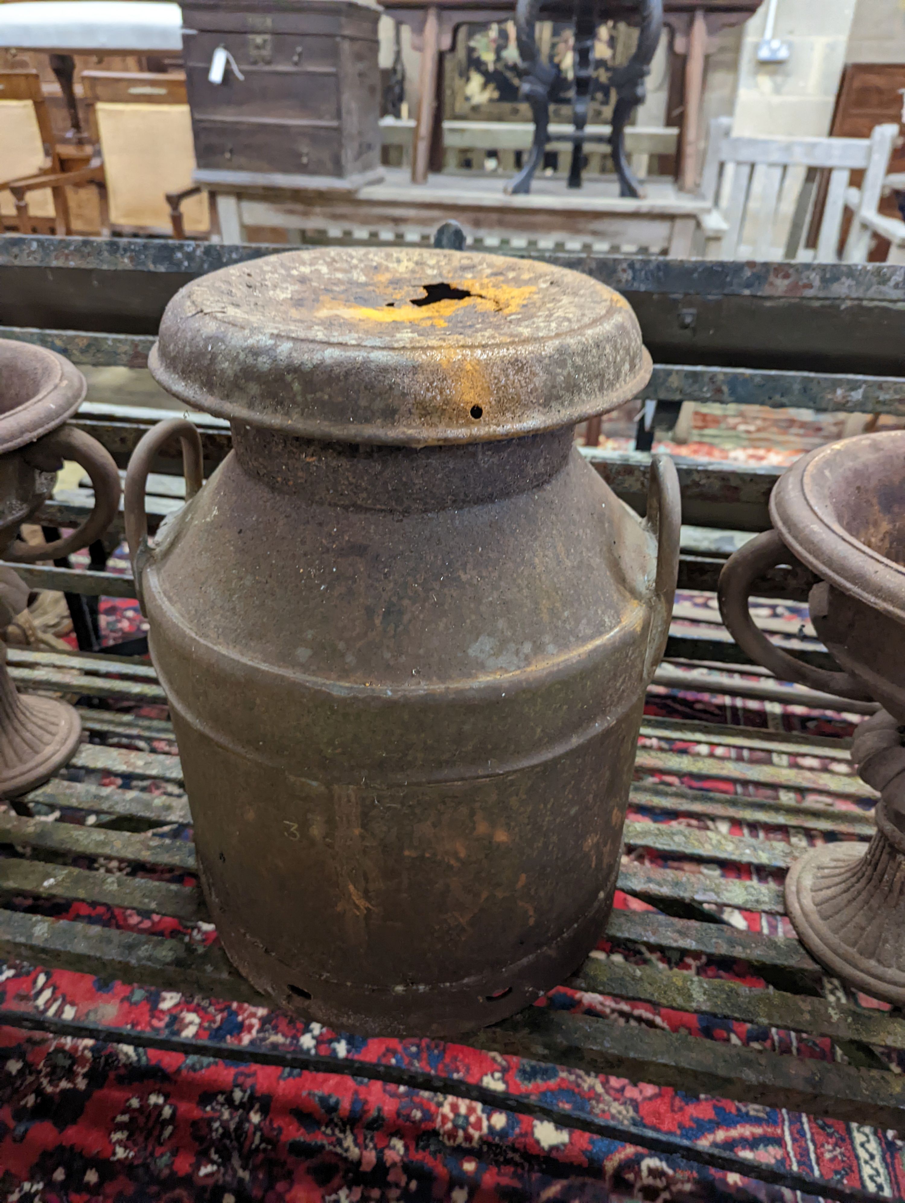A pair of circular cast iron campana urns, diameter 29cm, height 35cm together with an iron milk churn